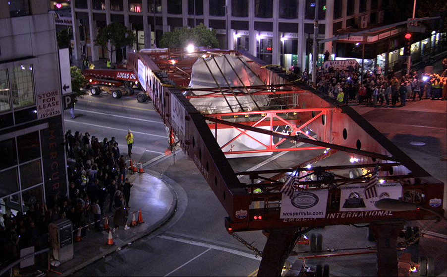A 340-ton granite boulder rounds Wilshire Boulevard in Los Angeles on its way to LACMA in a scene from "Levitated Mass," one of many films that tell a uniquely L.A. kind of story. Via First Run Features.