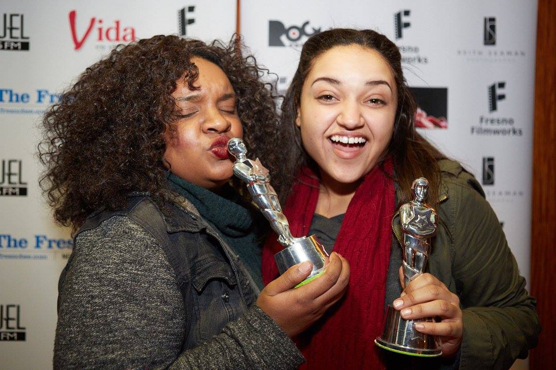 Two young women holding their Oscar statuettes and posing.